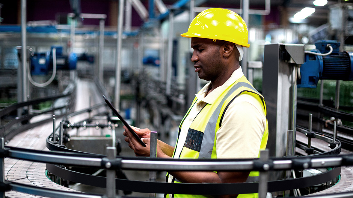 workman in hard hat working on a tablet