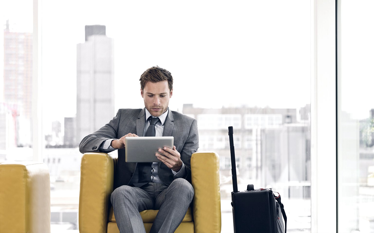 man sitting looking at tablet