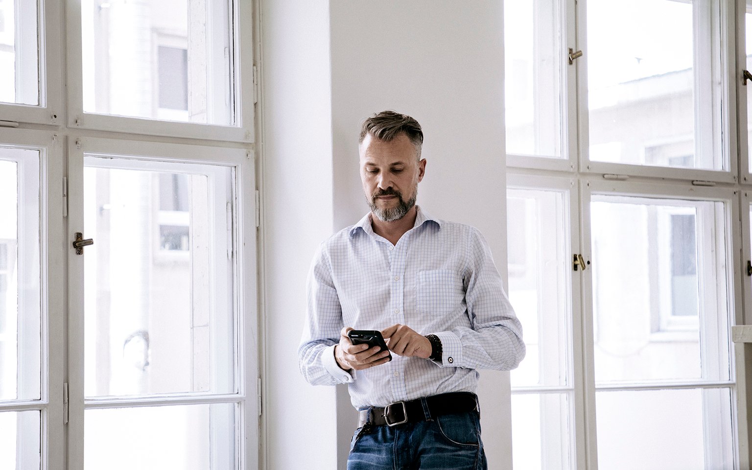 man in a office looking at the phone