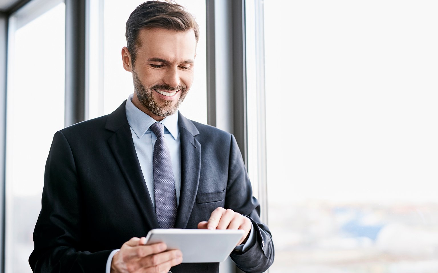 man smiling and using a tablet