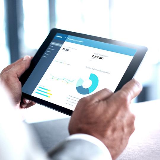 L'automatisation résout plusieurs défis dans les entreprises modernes close up of man holding a tablet with a graph on the screen