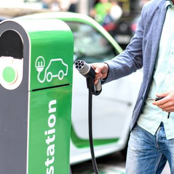 La borne de recharge pour véhicules électriques man charging car at charging point