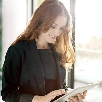 La gestion de contenu et la satisfaction clients femme suriant tablette tactile